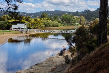 An angler at a lovely spot by the Erskine River near the Swing Bridge - Lorne, Victoria, Australia clipart