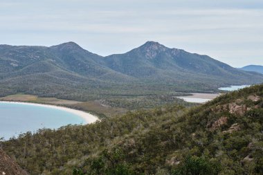 Wineglass Bay Gözcüsü 'nün ikonik hilal şeklindeki plajı Freycinet Yarımadası, Tazmanya, Avustralya