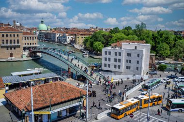 Venedik, İtalya - 10 Mayıs 2019: Venedik 'te Piazzale Roman toplu taşımacılığı, tramvay ve otobüs durağı, Büyük Kanal üzerinde Ponte della Costituzione ile birlikte, Santiago Calatrava tarafından tasarlanan bu köprü Stazione di Santa Lucia' yı Piazzale Roma 'ya bağlıyor. Venedik