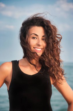 close up of smiling girl with long flowing hair wearing black tank top