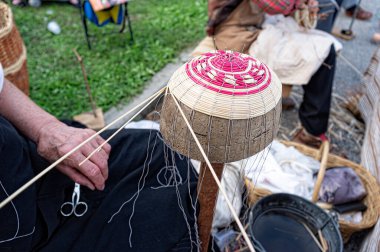 Yaşlı kişi dallar örerek sepet yapmakla meşgul. Hasır örme sanatı