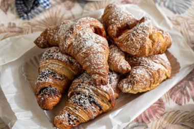 Kahvaltı için çeşitli reçel ve kremalarla dolu taze brioche tablası.