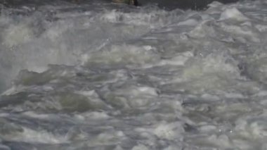 Şiddetli bir yağmurdan sonra, ağır çekimde, akan bir nehirde dalgalanan sular.