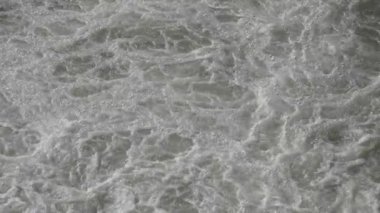 Şiddetli bir yağmurdan sonra, ağır çekimde, akan bir nehirde dalgalanan sular.