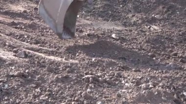 Kazı kovası çalışıyor. Kazı işe yarıyor. Güç küreği toprağı ve kayaları hareket ettiriyor. Bina temelleri kazılıyor