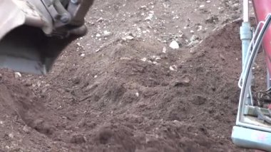 Kazı kovası çalışıyor. Kazı işe yarıyor. Güç küreği toprağı ve kayaları hareket ettiriyor. Bina temelleri kazılıyor