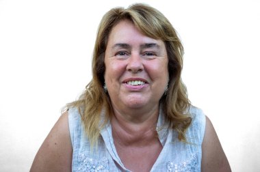 Sarışın, neşeli ve doğal bir şekilde gülümseyen olgun bir kadının yakın plan portresi. Mutluluk, güven, doğal güzellik ve özgün yaşam tarzı kavramı. Tarafsız arka plan, pozitif ifade, yaşlılık tarzı, zarifçe yaşlanma..