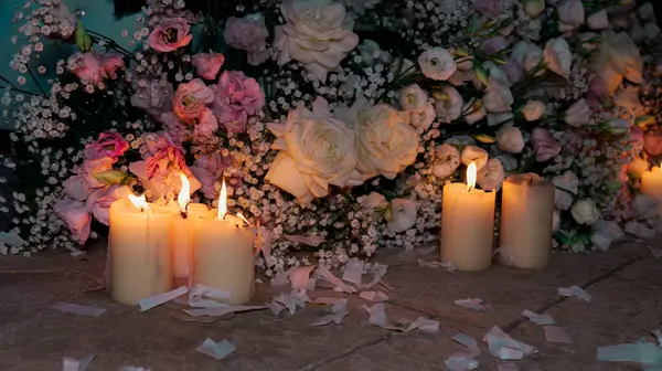 stock image Lighted candles on the floor with a floral arrangement of roses