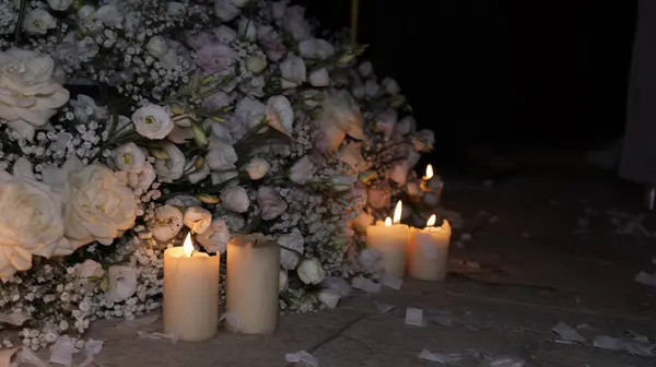 stock image Lighted candles on the floor with a floral arrangement of roses