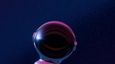 Üç boyutlu astronot miğferi holografik bir yoruma sahip, büyüleyici bir videoda güneş yansıması ve çeşitli renkler içeriyor. Tasarım için arkaplan modeli. Döngü videosu.