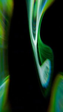Yeşil ve mavi kıvrımlı siyah bir arkaplan.