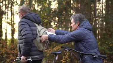 Sonbaharda bir sonbahar günü bisiklet süren birkaç emekli. Haritadaki yola bakıyorlar. 60 yaşın üstündeki insanlar, gençlik çağında. Yüksek kaliteli FullHD görüntüler