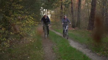 Sonbaharda bir sonbahar günü bisiklet süren birkaç emekli. 60 yaşın üstündeki insanlar, gençlik çağında. Yüksek kaliteli FullHD görüntüler
