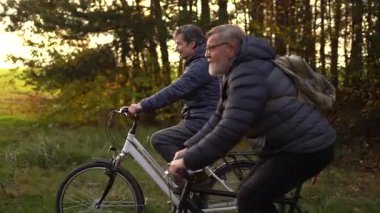 Sonbaharda bir sonbahar günü bisiklet süren birkaç emekli. 60 yaşın üstündeki insanlar, gençlik çağında. Yüksek kaliteli FullHD görüntüler