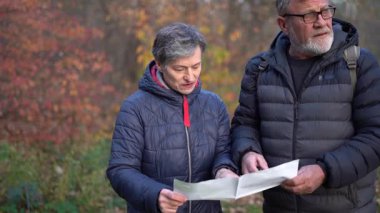 Güzel emekli çift haritaya bakıyor ve turist rotası planlıyorlar. 60 yaşın üstündeki insanlar, gençlik çağında. Yüksek kaliteli FullHD görüntüler