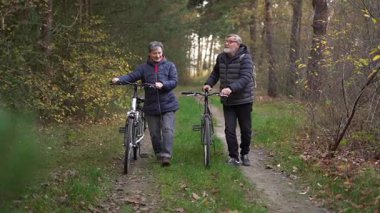 Sonbaharda bir sonbahar günü bisiklet süren birkaç emekli. 60 yaşın üstündeki insanlar, gençlik çağında. Yüksek kaliteli FullHD görüntüler