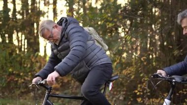 Sonbaharda bir sonbahar günü bisiklet süren birkaç emekli. 60 yaşın üstündeki insanlar, gençlik çağında. Yüksek kaliteli FullHD görüntüler