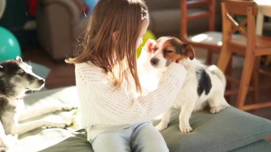 7 yaşındaki bir kız küçük sevimli bir köpeğe sarılıyor. Yüksek kaliteli FullHD görüntüler