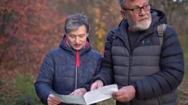 Güzel emekli çift haritaya bakıyor ve turist rotası planlıyorlar. 60 yaşın üstündeki insanlar, gençlik çağında. Yüksek kaliteli FullHD görüntüler