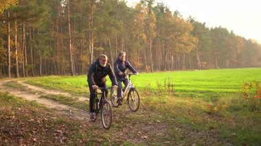 Sonbaharda bir sonbahar günü bisiklet süren birkaç emekli. 60 yaşın üstündeki insanlar, gençlik çağında. Yüksek kaliteli FullHD görüntüler