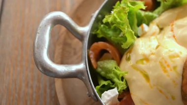 Yağda yumurta, mevsim tohumları, ekmek ve ahşap masada taze salata ile lezzetli bir kahvaltı.