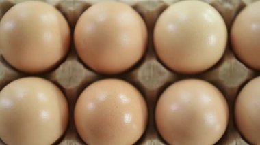 Kağıt paketin içinde tavuklu organik yumurta ve kırık yumurta kabuğu.