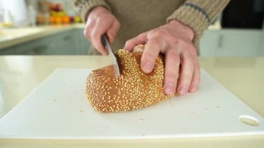 Ekmek bıçağıyla ekmek kesen bir adam