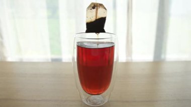 Kaynamış su bardağında siyah çay poşeti demleme işlemi