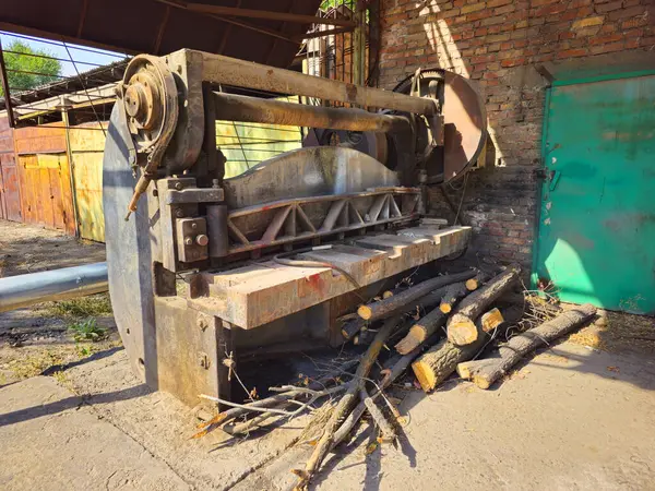 Eski, paslı, çalışmayan metal kesme makinesi. Makine eski bir fabrikanın terk edilmiş bir bahçesinde..