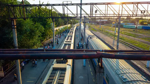 İstasyon önlüğü. Tren geldi. Yolcular geliyor. Platformdaki insanlar. Bavullu insanlar var. Köprü merdivenleri. Köprü.