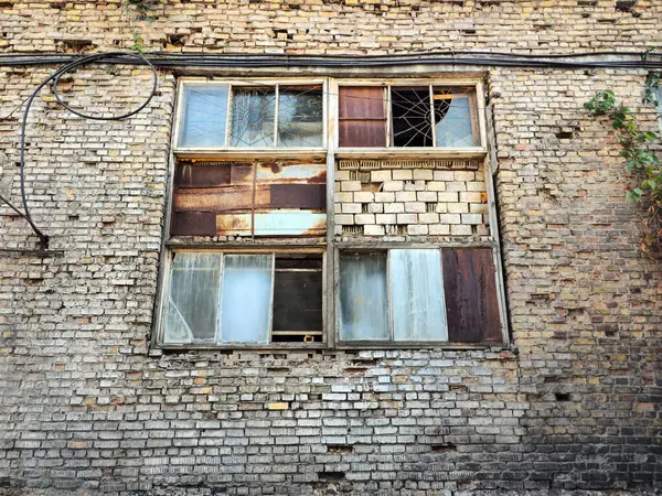 Terk edilmiş bir binanın kırık penceresi. Kırık camlı çökmüş bir bina. Camsız bir pencere.