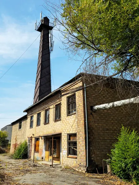 Eski terk edilmiş bir fabrika. Paslı bir kule. Hücresel antenler. Çöken bir bina..
