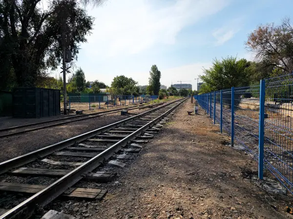 Perspektifte raylar, şehirde demiryolu geçidi.