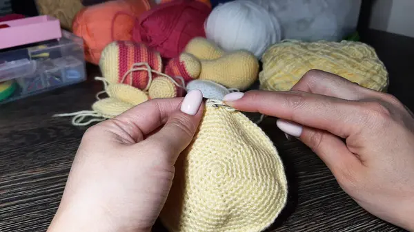 Ellerini yaklaştır, tığ işi. Amigurumi oyuncakları örüyorum. Çeşitli iplikler ve örgü oyuncakları.