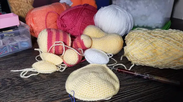 Amigurumi oyuncakları örüyorum. Örgü oyuncakları için çeşitli iplikler ve dolgular. Oyuncağı monte etmek için örülmüş parçalar.