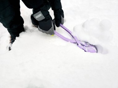 Çocuk oynamak için kartopu yapıyor. Karlı kış. Bir sürü kar, kartopu, kartopu yapmak için oyuncak.
