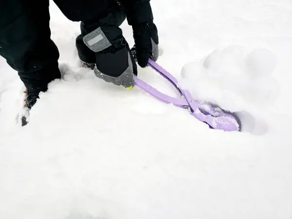 Çocuk oynamak için kartopu yapıyor. Karlı kış. Bir sürü kar, kartopu, kartopu yapmak için oyuncak.
