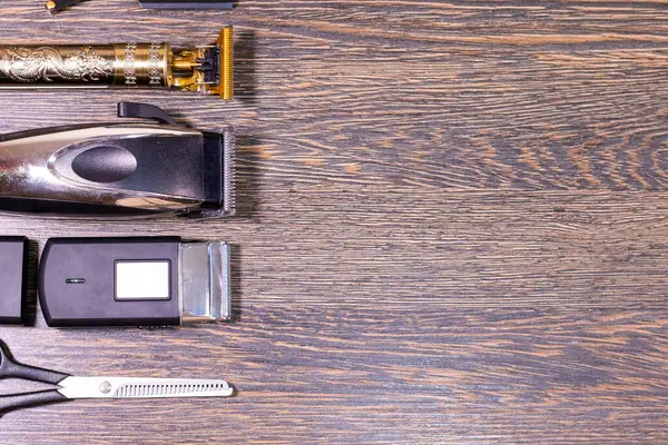 Profesyonel berber aletleri düzgün bir şekilde tahta bir yüzeye yerleştirilmiş ve sağ tarafta boş alan var..