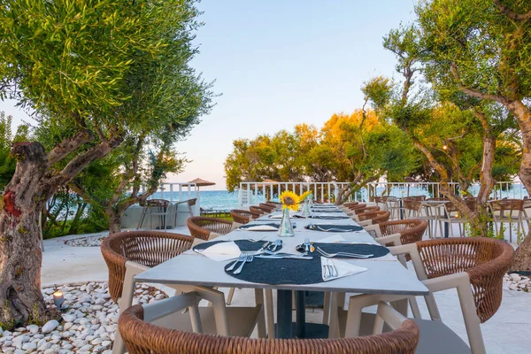Tables in restaurant on the terrace . Zakynthos, Greece. Superb summer mood, outdoor restaurant. Romantic vibes, summer colors under blue sky