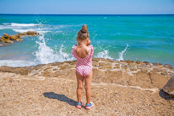 Küçük kız suya girmekten korkuyor. Zakynthos, Yunanistan