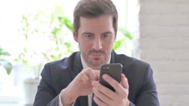 Genç Yetişkin İş Adamı Ofisteki Akıllı Telefon 'da Çevrimiçi Başarı Kutlaması