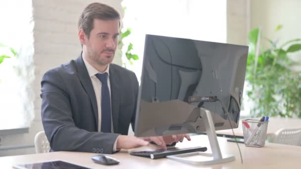 デスクトップコンピュータを使用している間に若い大人のビジネスマンによって親指アップ — ストック動画
