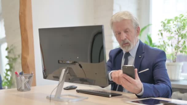 在智能手机和计算机上工作的老商人 — 图库视频影像