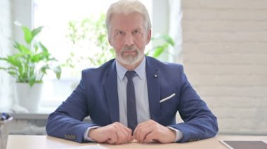 Gülümseyen yaşlı işadamı Kameraya bakıyor 