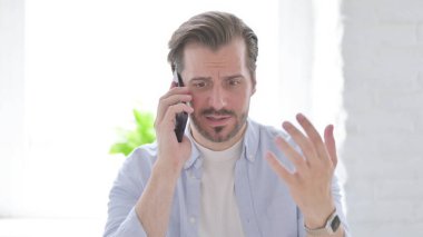 Mature Man Talking Angrily on Smartphone
