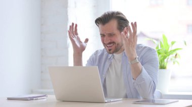 Mature Man Reacting to Loss While using Laptop