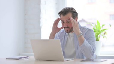 Angry Mature Man Working on Laptop in Office