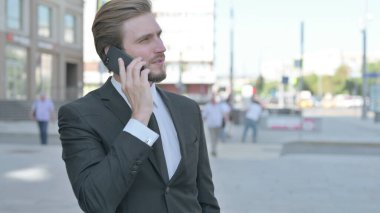 Portrait of Middle Aged Businessman Talking on Phone Outdoor