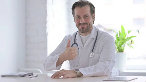 Male Doctor Showing Thumbs While Sitting Clinic — Foto Stock