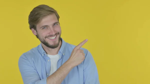 Casual Young Man Pointing Side Yellow Background — Photo